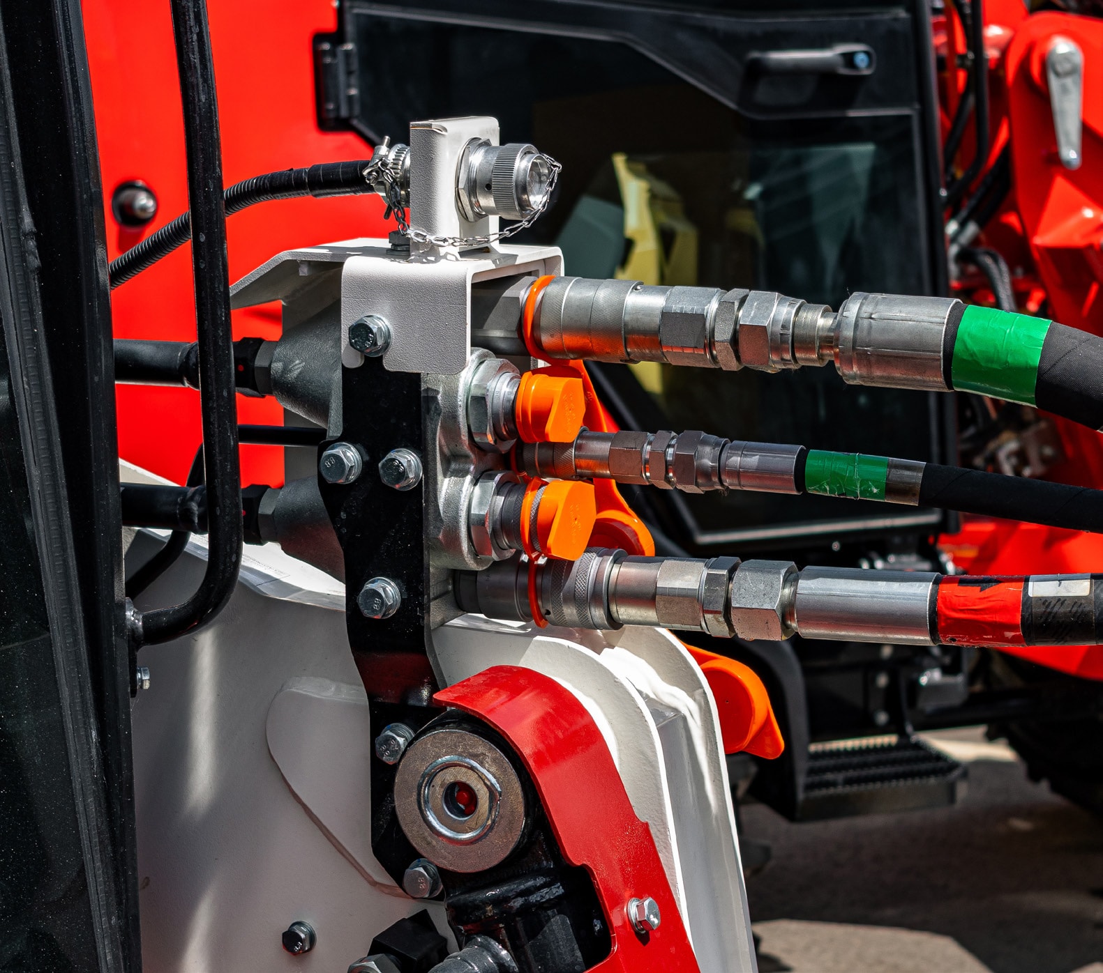 Hydraulic quick disconnect couplings on skid steer loader with color-coded hose connections