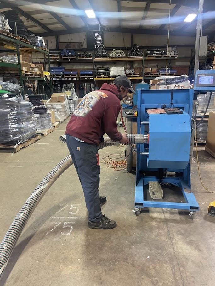B&B Hose technician crimping a custom hose assembly at the Chesapeake shop