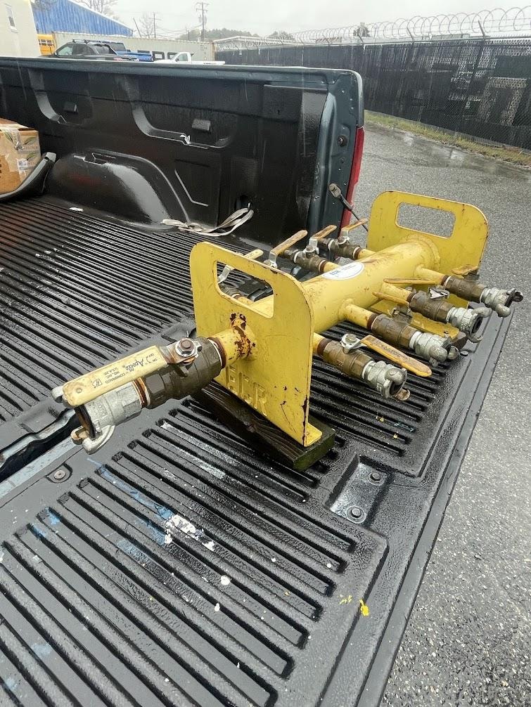 Yellow multi-port air manifold assembly on a delivery truck headed to a Hampton Roads shipyard