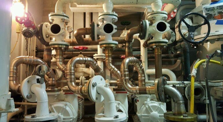 Onboard ship valve and pipe inspection — complex marine valve manifold with gauges and fittings